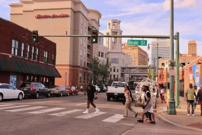 People crossing a crosswalk on Beale Street in Memphis, Tennessee.