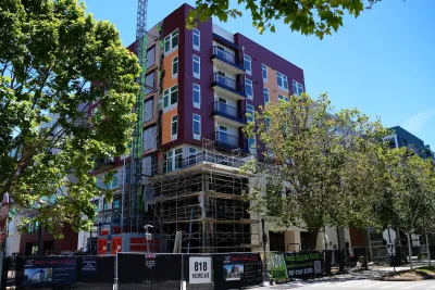 Modern dark purple and orange apartment building in Santa Cruz, California on sunny day.