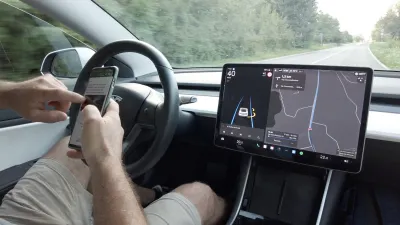 Person texting while at the wheel of a Tesla vehicle implying self-driving features.