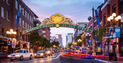 Neon sign over street for historic Gaslamp Quarter district of San Diego, CA at dusk.