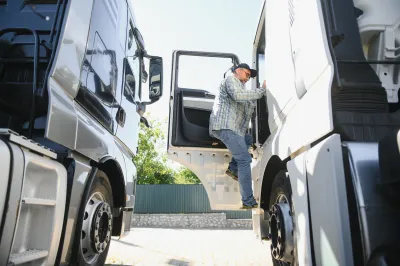 Man climbing into 18-wheeler truck.