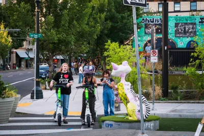 Teens on scooters crossing a crosswalk.