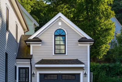 Close-up on gabled roof with window over garage.