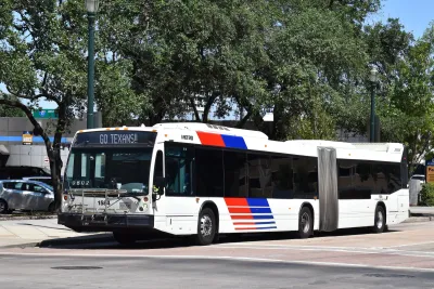 White articulated transit bus with blue and red stripes in Houston, Texas.