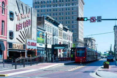 A red light rail train driving down Main Street in Houston, Texas.