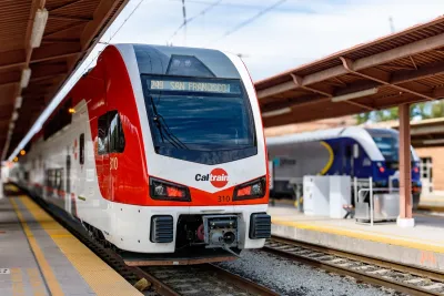 ELectric red and white Caltrain train at outdoor covered platform.