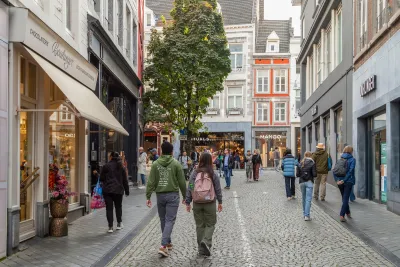 People walking on cobblestone street between old buildingsin Maastricht, Netherlands.