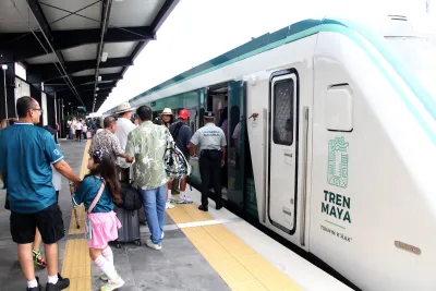 Passengers boarding a white Tren Maya train in Merida, Yucatan, Mexico.