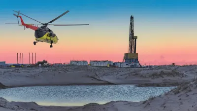 An oil and gas field in the Arctic with a helicopter flying overhead.