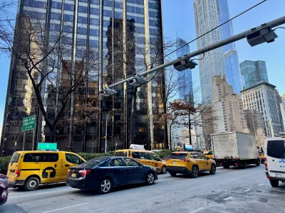 Cars driving under automatic congestion pricing toll machines on Broadway next to the Trump International Hotel in Manhattan, New York City.