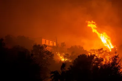 The Eaton fire burns in Sierra Madre. A home can be seen through the flames.