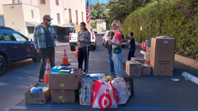 Los Angeles wildfire victims stand in street with bags of supplies in January 2025.