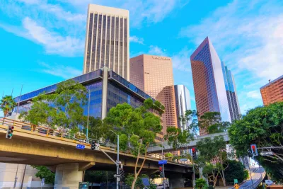 Striking view of Los Angeles financial skyline featuring the World Trade Center and nearby buildings, showcasing urban design against a bright sky.