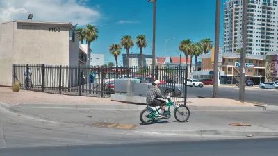 Person on bike rides onto sidewalk on curb cut in Las Vegas, Nevada.