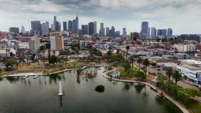 Aerial of lake in Macarthur Park in Los Angeles, California with downtown skyline visible in background.