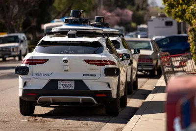 Two white Waymo self-driving cars parked nect to curb in Mountain View, California.