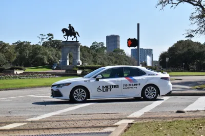 A MetroLift car driving over a crosswalk on a clear, sunny day.