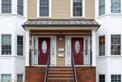 Two-story duplex with matching dark red doors in Boston, Massachusetts.