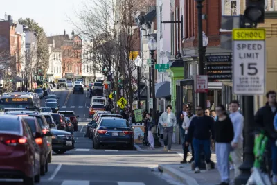 Pedestrians and cars on busy Washington D.C. street and sidewalk.