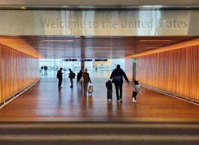 "Welcome to the United States" sign over wide corridor at U.S. airport.