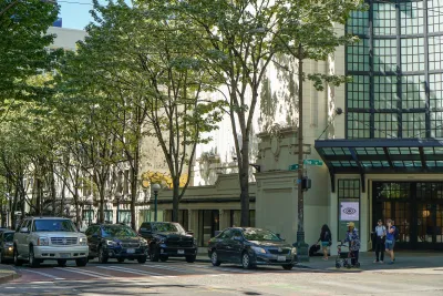 Street in Seattle, Washington with large trees shading sidewalk with glass storefront.