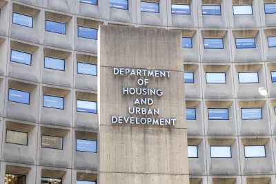 The Department of Housing and Urban Development Building sign. The cement sign is flanked on either side by rows of windows.