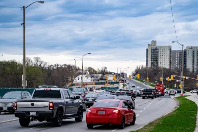 A large road with heavy traffic amidst residential buildings