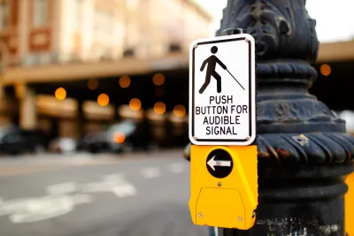 Close-up on pedestrian button with "LOush button for audible signal" below silhouette of person with cane.