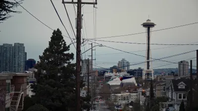 Seattle skyline with Space Needle and power lines in foreground.