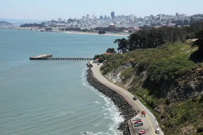 Aerial of paved road on San Francisco coastline.