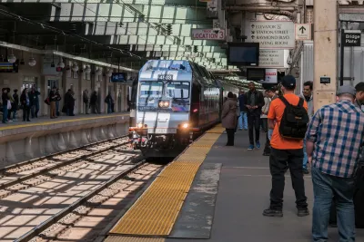 NJ Transit train pulling up to platform with passengers waiting.