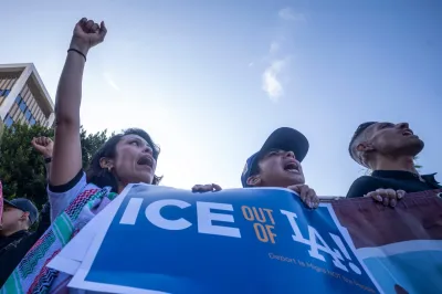 Protesters holding a blue "ICE out of LA" sign with LA Dodgers logo in Los Angeles.