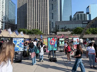 Soccer fans walk around World Cup countdown event in plaza in downtown Toronto, Canada.