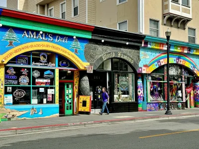 Street view of Amal’s Deli, World Famous Tattoo, and Love on Haight storefronts decorated with bright murals and rainbow-colored psychedelic designs.