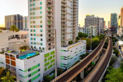 High-rise apartment buildings next to elevated rail line in dense urban neighborhood in Miami, Florida.