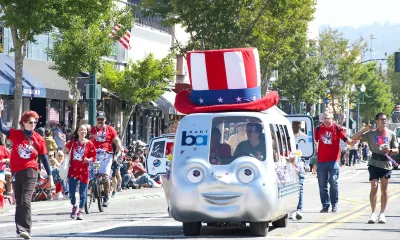 BART train shaped float with face on front and Uncle Sam-style top hat in 4th of July parade.