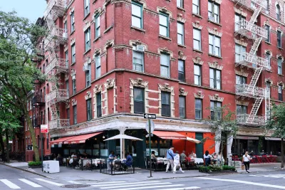 Old apartment building with restaurants on ground floor in NYC.