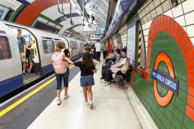 Passengers walk through a London Tube tunnel