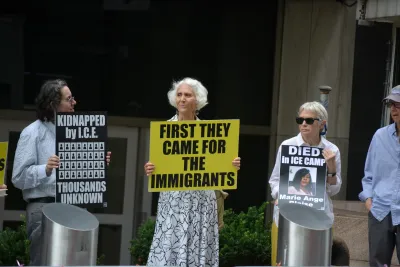 Three older women hold up signs protesting deportation and ICE abuses in New York City.
