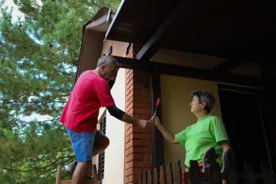 Older couple working on the exterior of their home.
