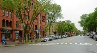 Wide main street with five-story red brick building on left in downtown Saratoga Springs, Florida.