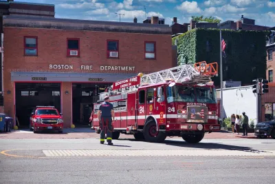 Boston FD fire station with red fire truck halfway out of the door.