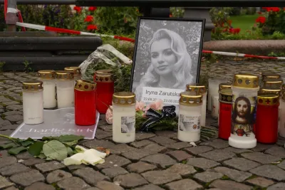 Memorial for Iryna Zarutska in Berlin, Germany with black and white portrait surrounded by candles.