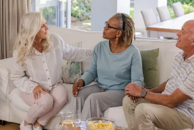 Group of seniors sitting on a sofa talking.
