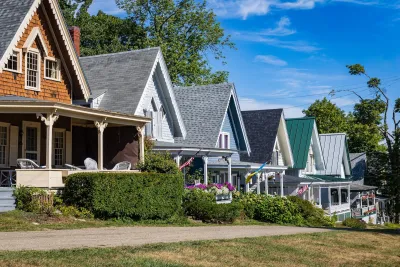 Single-story colorful wood houses with strongly pitched roofs in Maine.