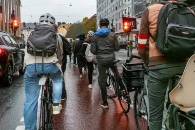 Group of people on bikes stopped at red light on street in Stockholm, Sweden.