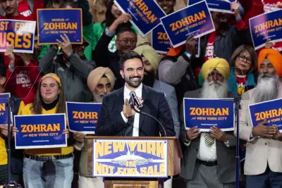 Mayoral candidate Zohran Mamdani speaks during 'New York is not for sale' rally at Forest Hill Stadium in New York. A diverse crowd behind him holds his campaign signs.