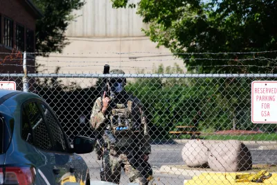 Armed guard standing behind fence at Chicago ICE detention facilities.