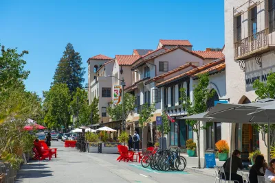 Street with outdoor seating and bike racks next to Spanish Revival-style buildings in Palo Alto, California.