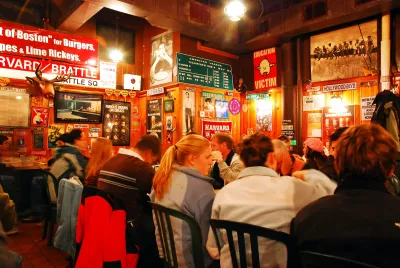 Cozy family-style restaurant with large group of people sitting at long table.